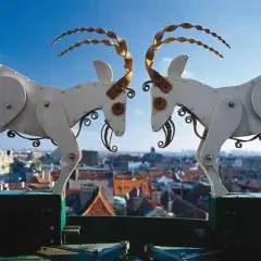 Mechaniczne koziołki poznańskie, bohaterowie legendy, na tle miasta.